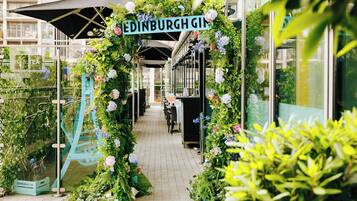 A pathway lined with floral decorations and a sign reading 'EDINBURGH GIN'.