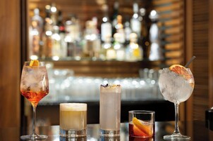 A bar area with various drinks and bottles in the background.