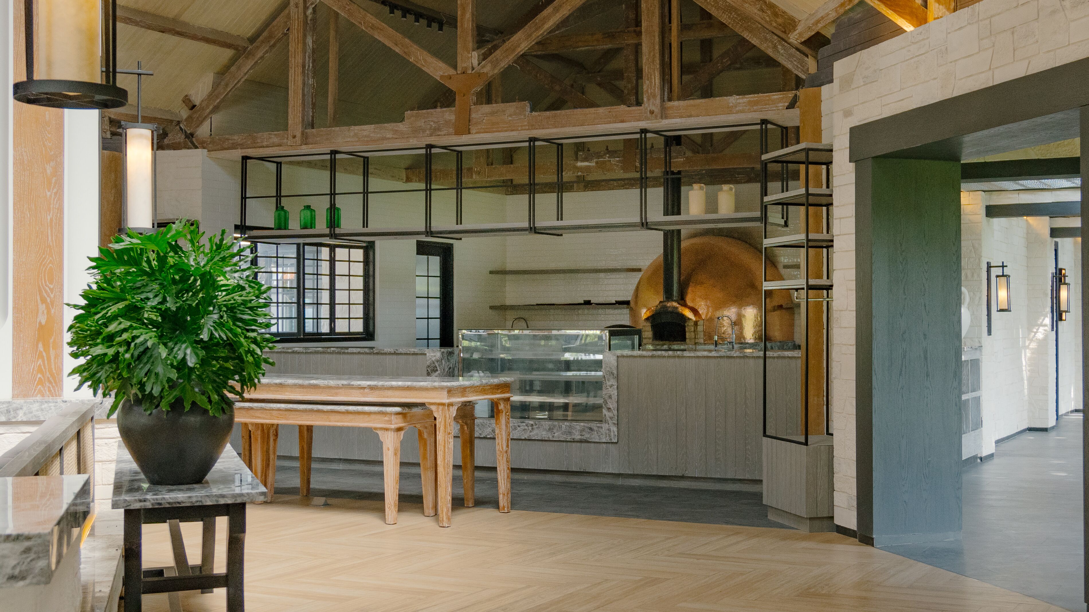 Una cocina moderna con vigas de madera, un horno grande y una planta en maceta.