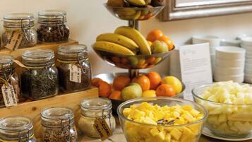 A variety of food items including jars of spices, a bowl of diced pineapple, and a fruit display with bananas and oranges.