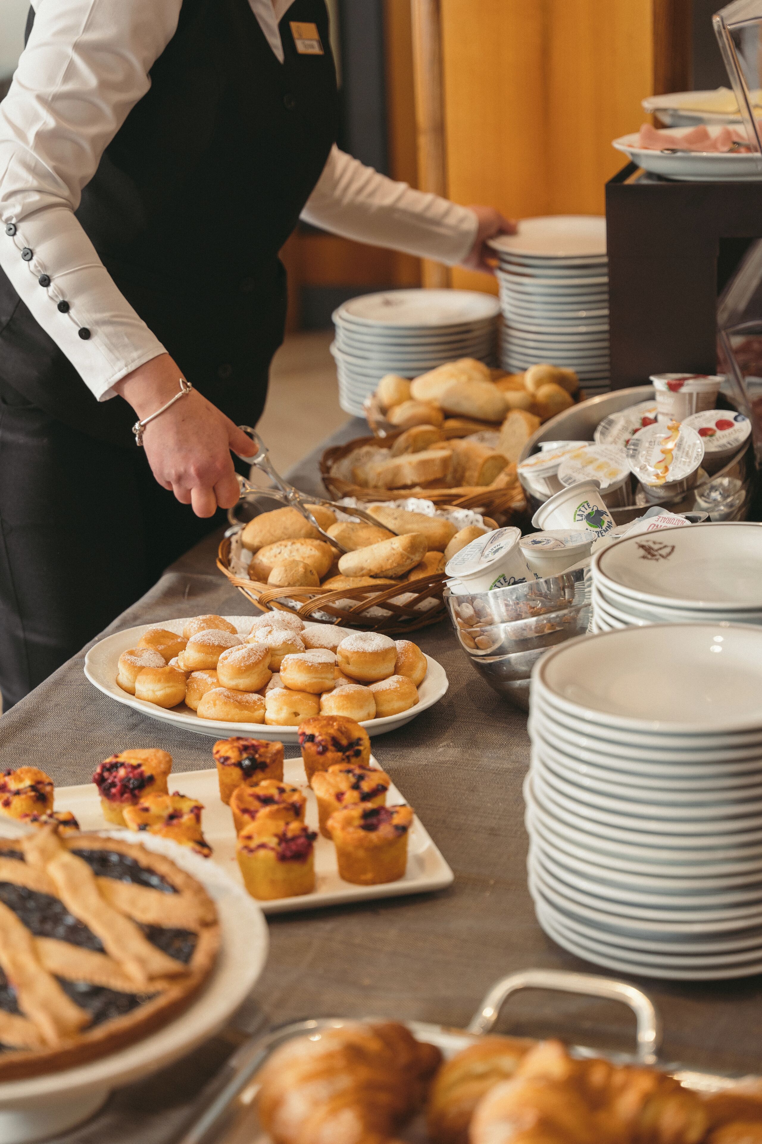 A buffet setup with various baked goods and pastries.