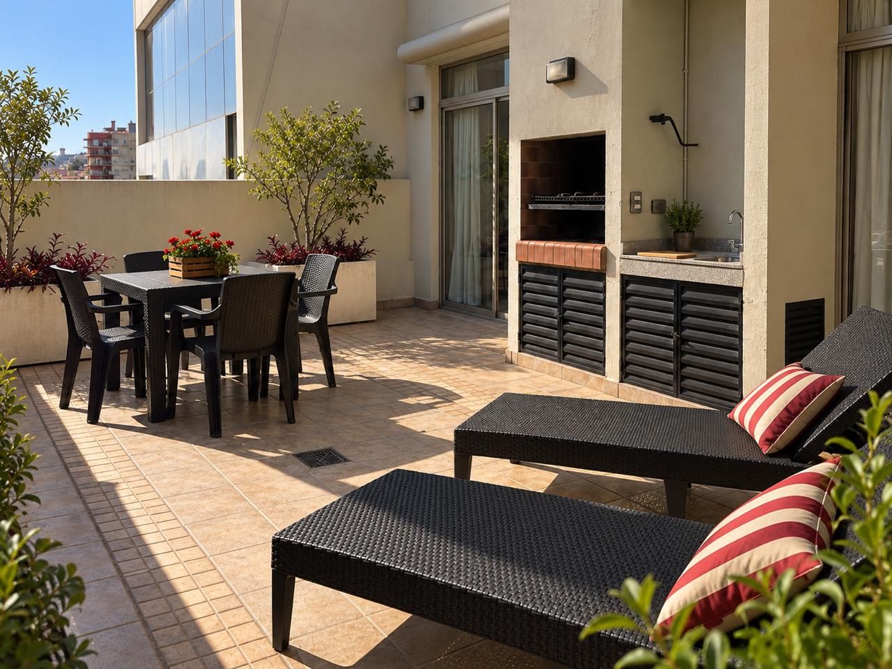 Une terrasse extérieure avec une table et des chaises pour les repas, un barbecue et des fauteuils de jardin.