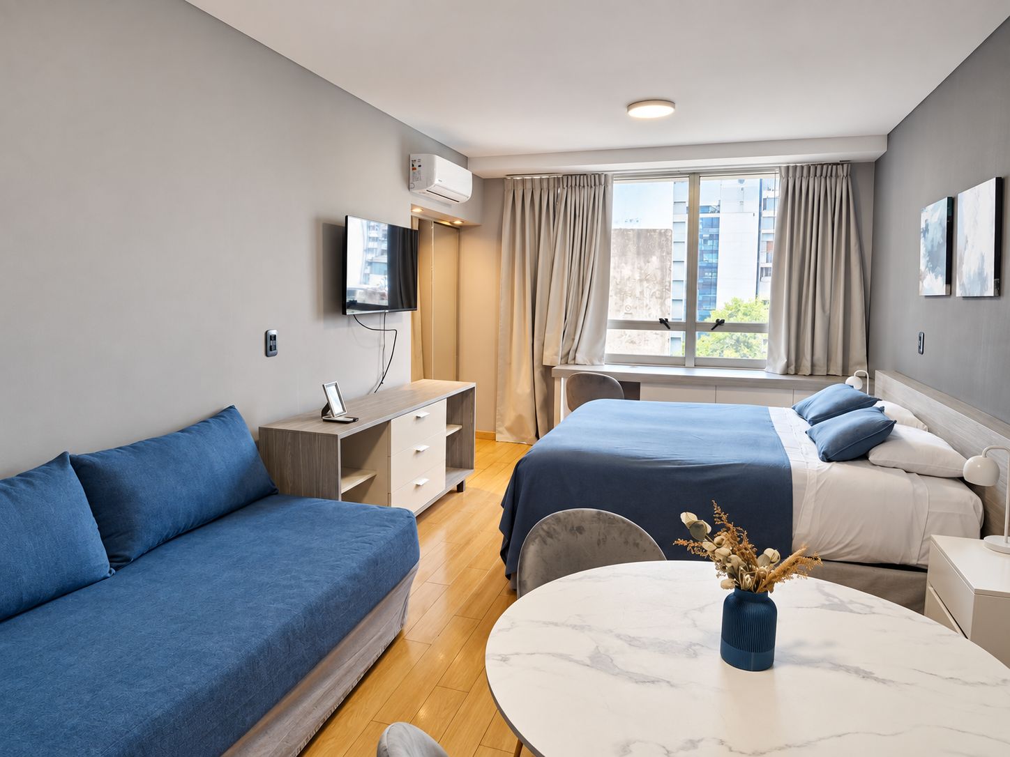 Une chambre d’hôtel moderne équipée d’un lit, d’un canapé, d’un bureau et d’une télévision.