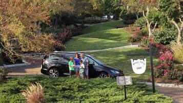 A black SUV parked in a landscaped area with a sign indicating an exit.