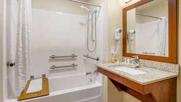 A bathroom with a bathtub, a shower, a sink, and a mirror.