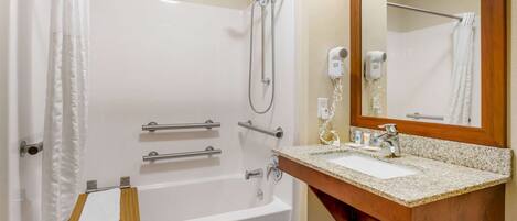 A bathroom with a bathtub, a shower, a sink, and a mirror.