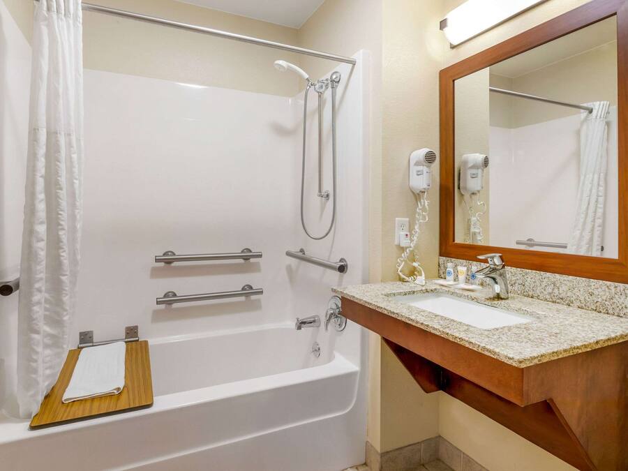 A bathroom with a bathtub, a shower, a sink, and a mirror.