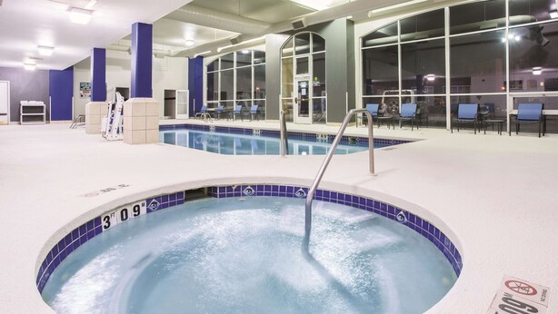 An indoor swimming pool with a 3 FT 9 IN depth marker, surrounded by blue chairs and a white pool deck. - La Quinta Inn & Suites by Wyndham Gallup (Gallup)