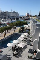 Zona de piscina en la azotea con mobiliario exterior y vistas al puerto deportivo.