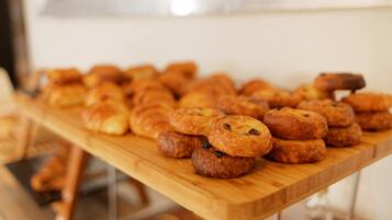A wooden table with various pastries and baked goods.