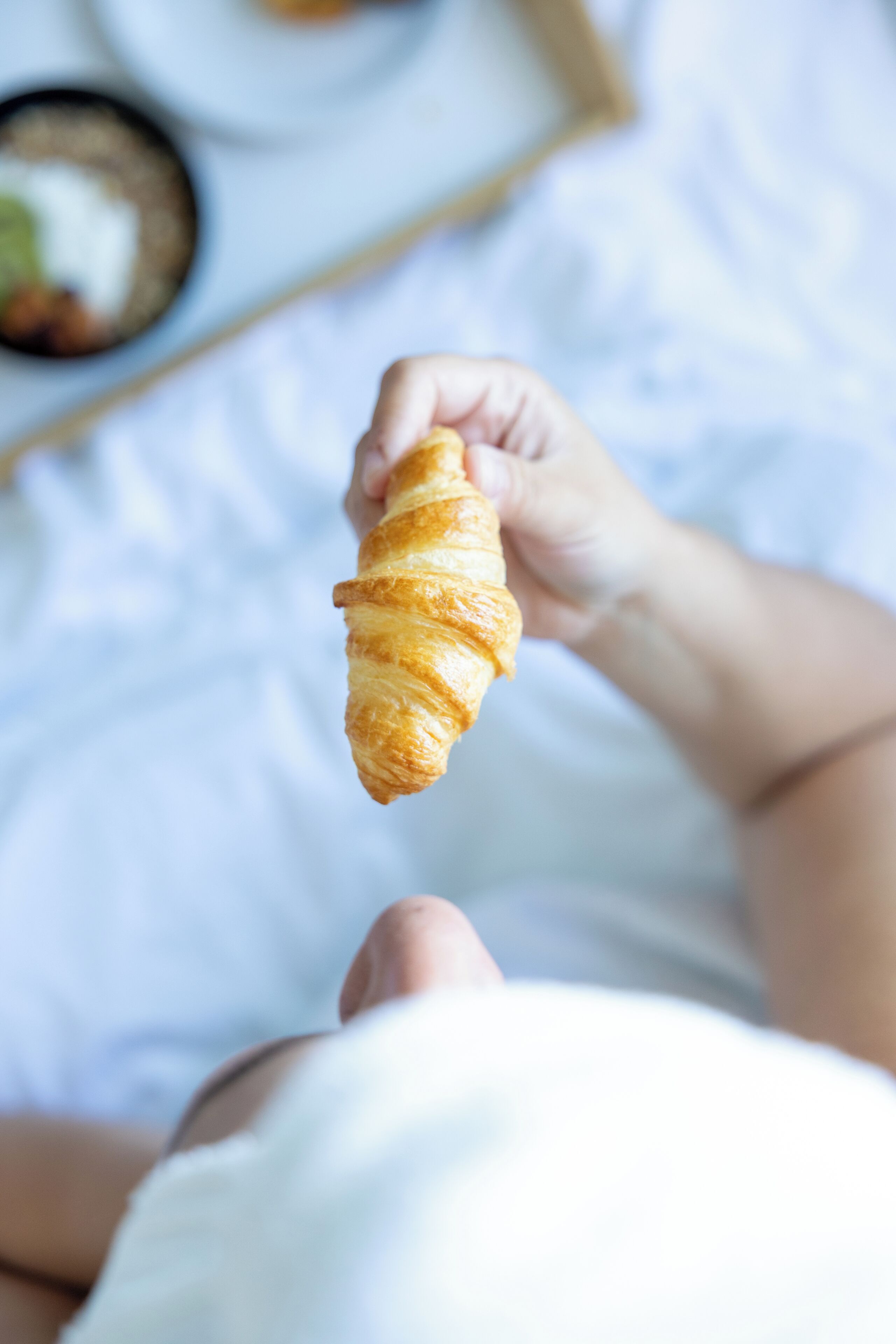 Uma pessoa segurando um croissant.