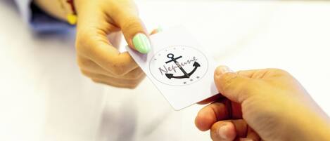 Une personne remet une carte ornée d’un symbole d’ancre à une autre personne.