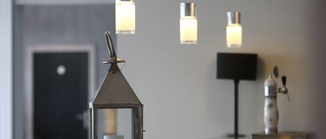 A modern interior with a reception desk, a decorative lantern, and hanging pendant lights.