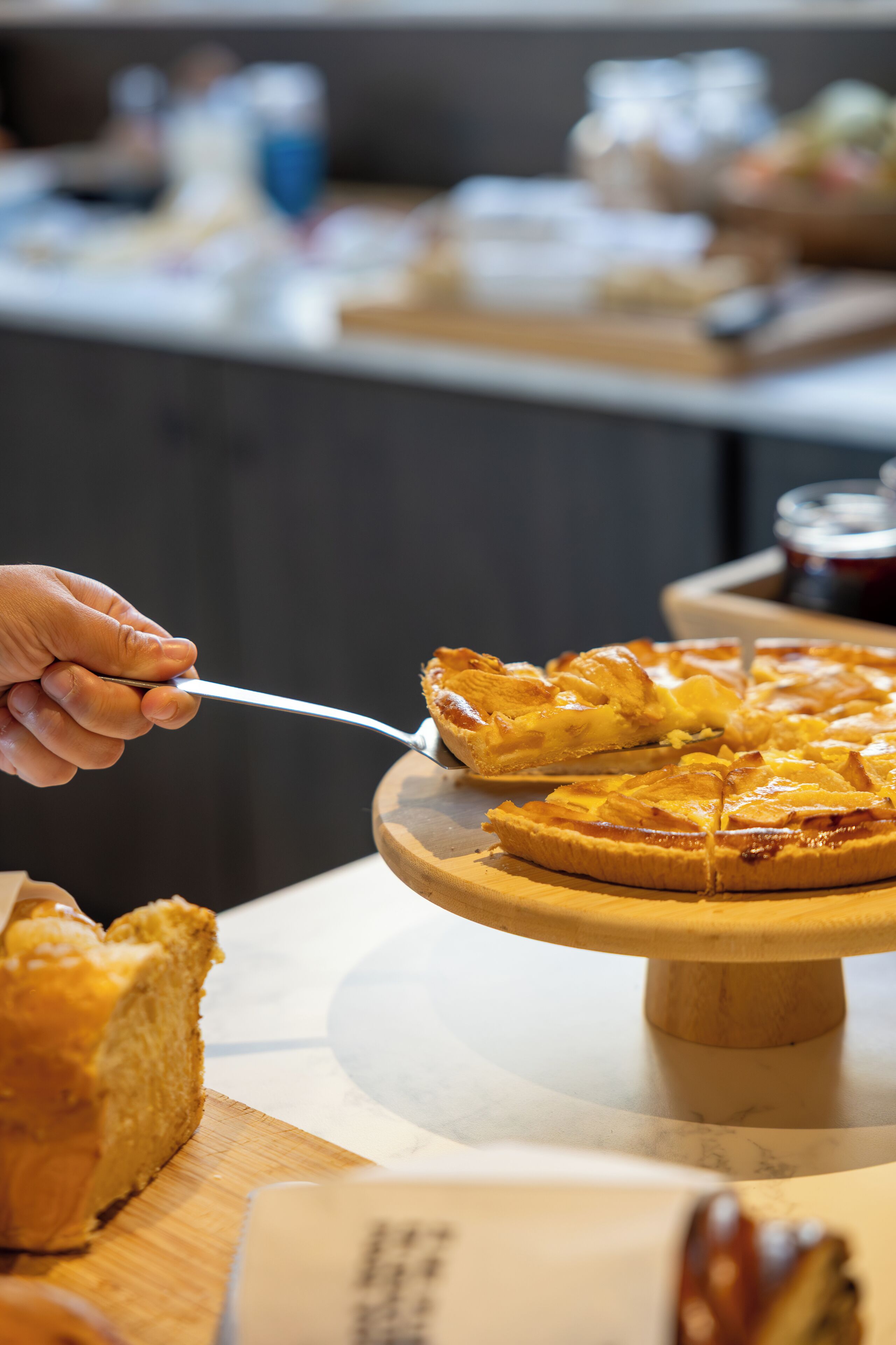 A person cutting a pie on a wooden stand.