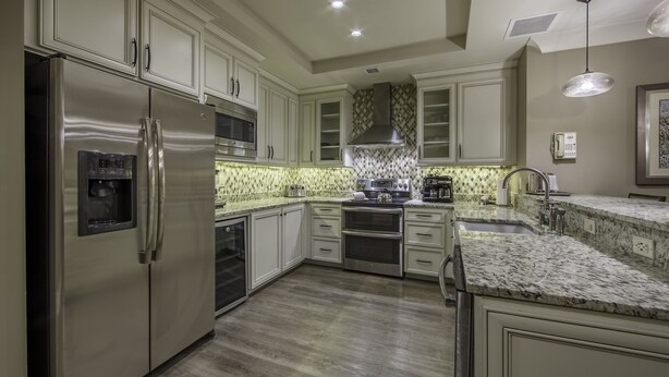 Una cocina moderna con electrodomésticos de acero inoxidable, encimera de granito y salpicadero decorado.