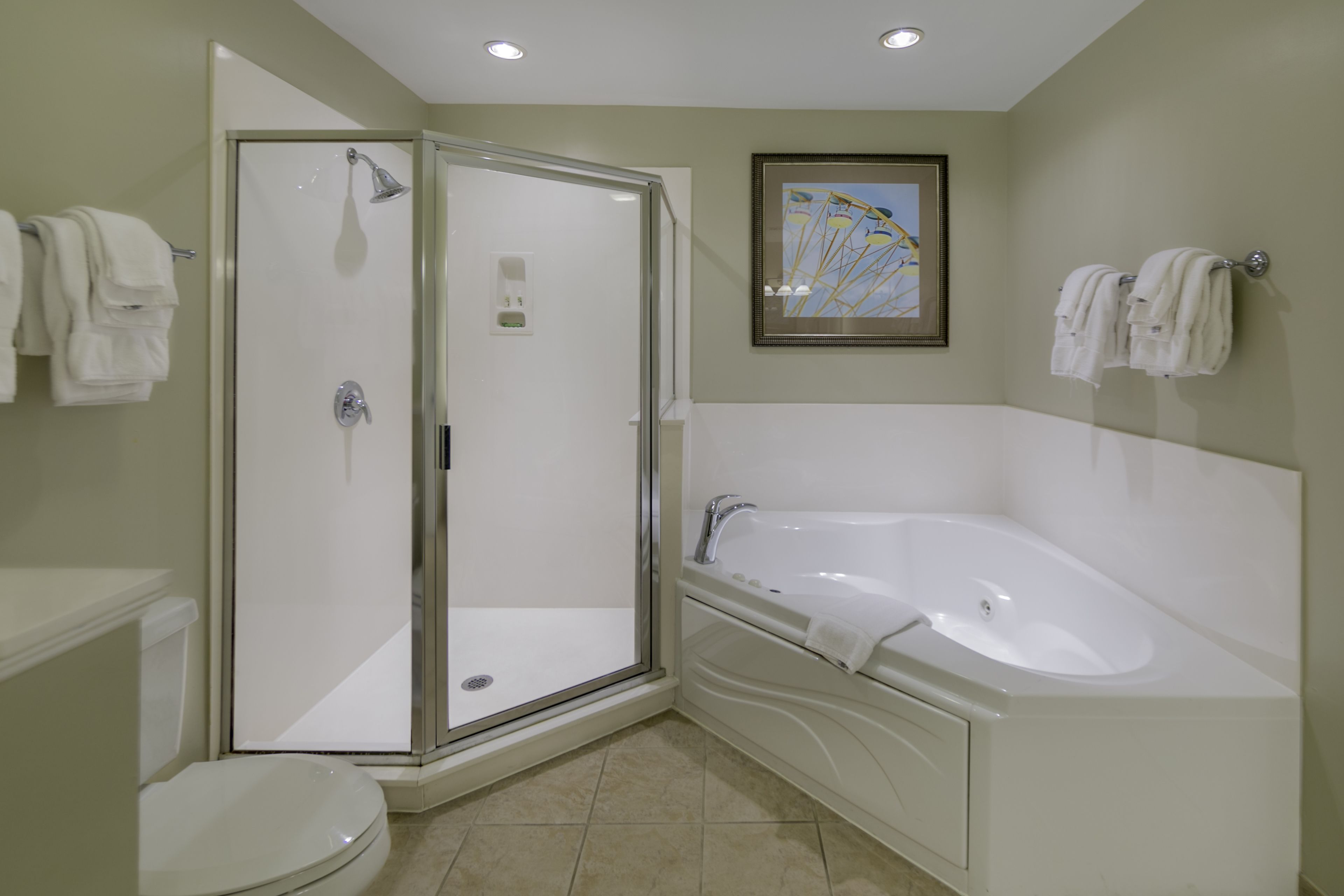 A bathroom with a glass-enclosed shower, a white bathtub, and a toilet.
