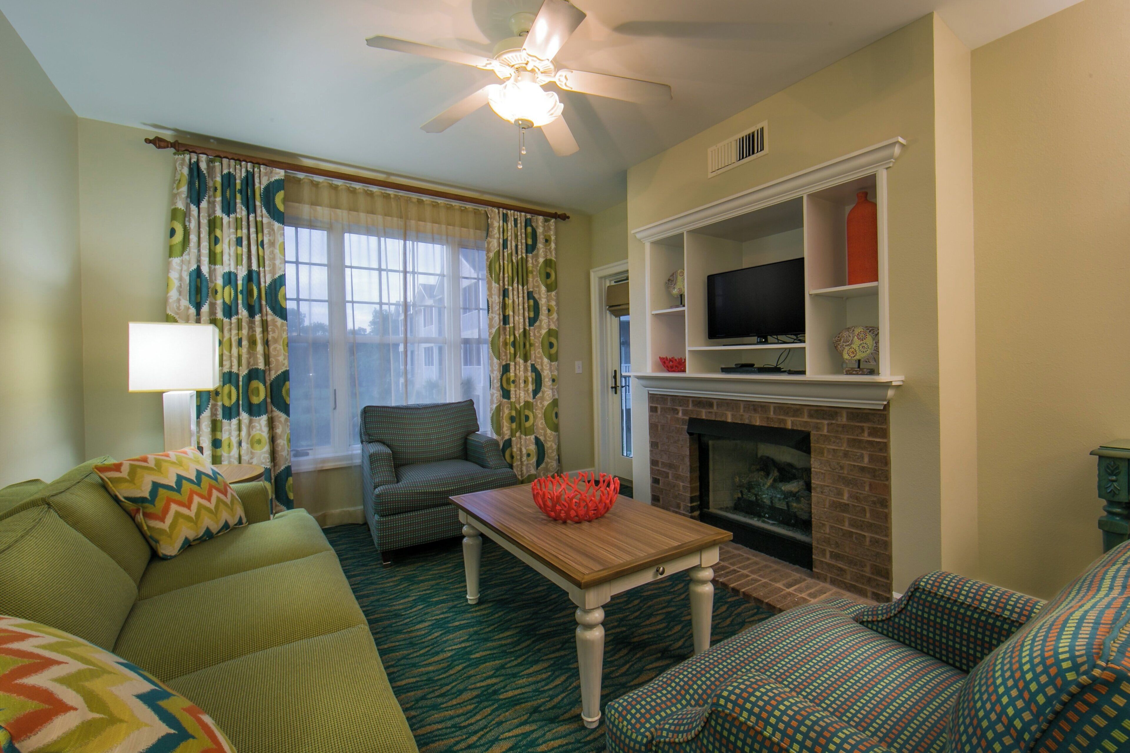 A living room with a sofa, armchair, and a fireplace.