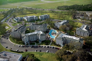 An aerial view of a hotel complex with multiple buildings, a swimming pool, and a parking lot. - Holiday Inn Club Vacations South Beach Resort by IHG (Myrtle Beach)
