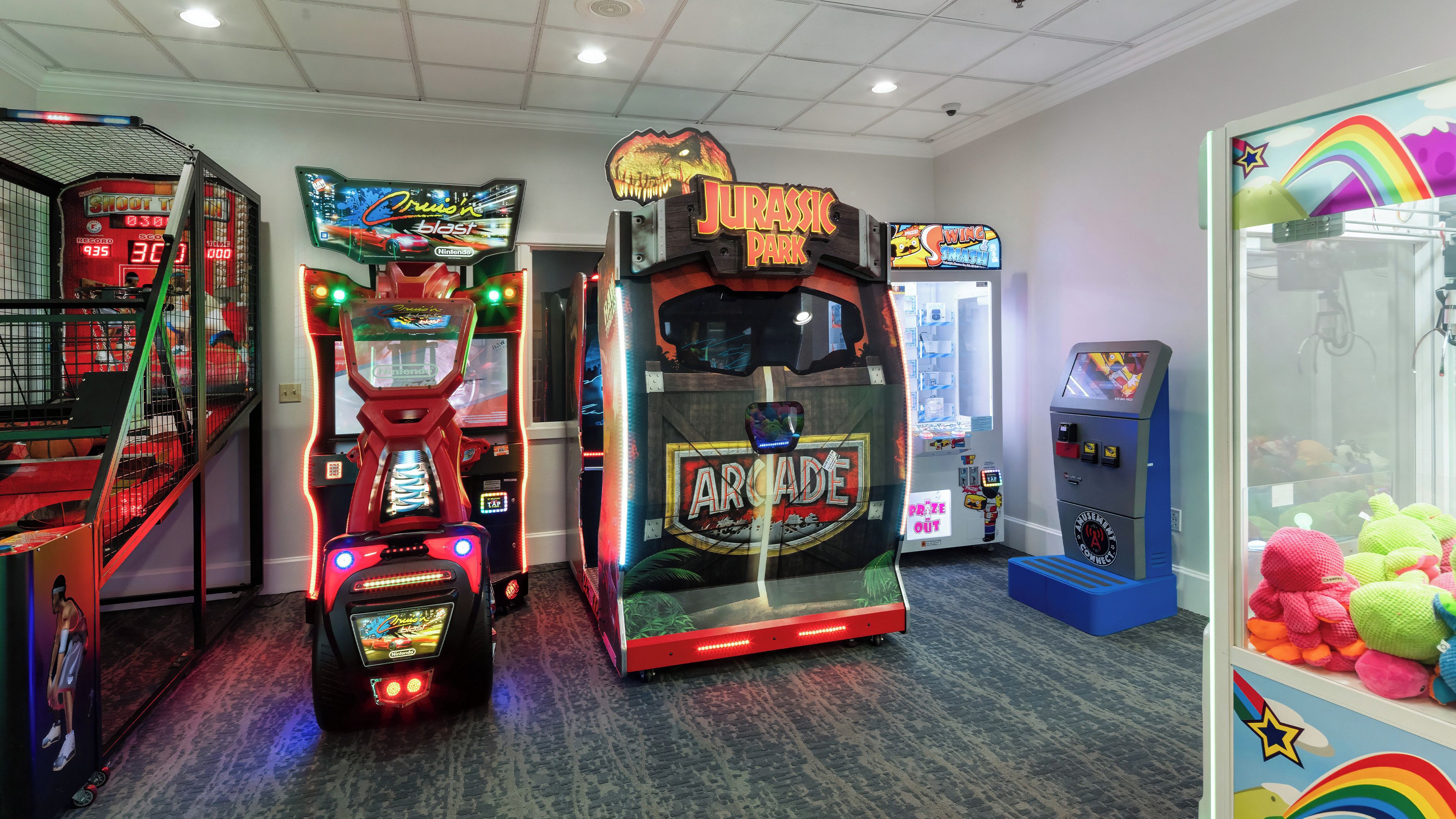 A gaming arcade with various machines, including a 'Cruisin' blast' and 'Jurassic Park' game.