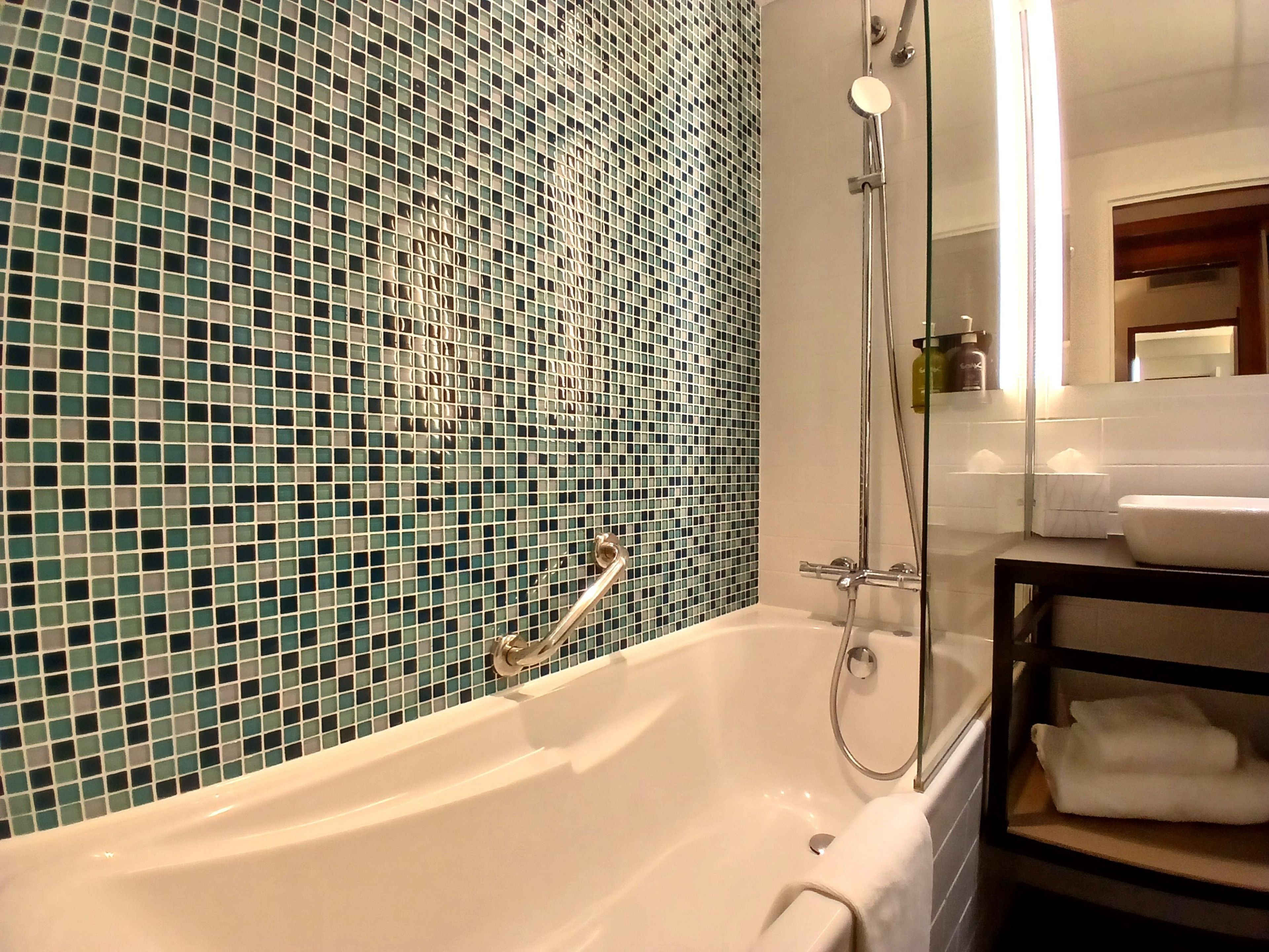 Un baño con bañera, ducha y lavamanos.