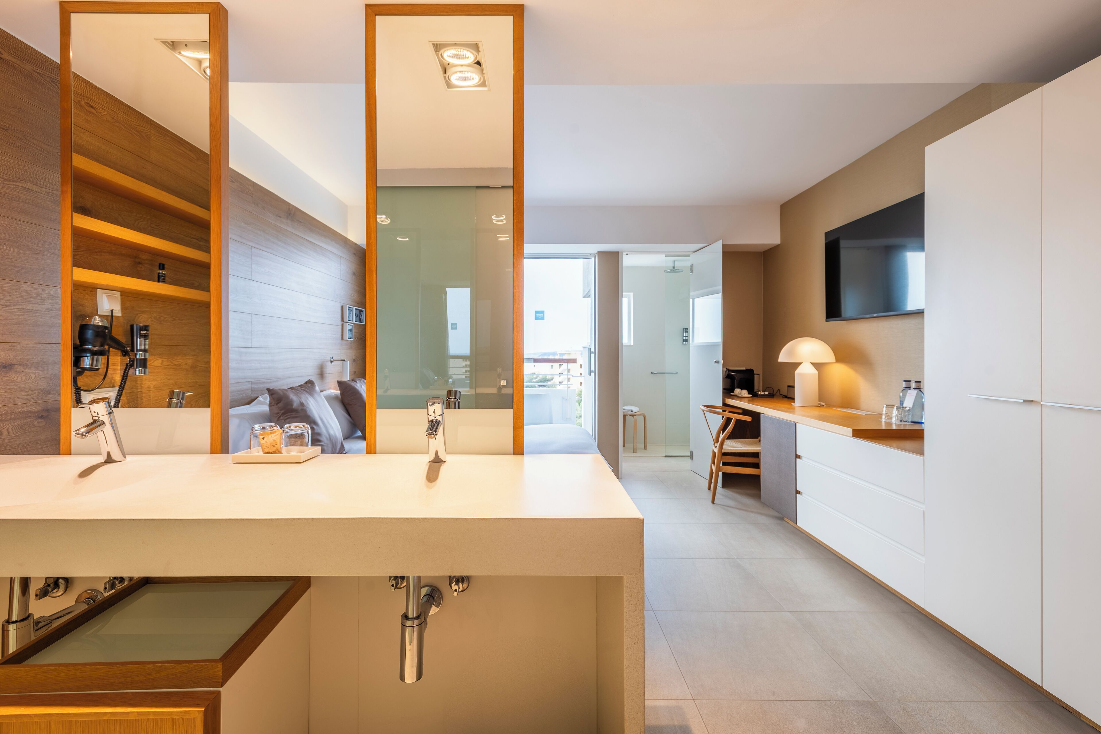 A modern bathroom with a large mirror, a sink, and a shower.