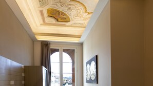 Une pièce dotée d’un plafond décoratif, d’une grande fenêtre et d’une œuvre d’art encadrée au mur.
