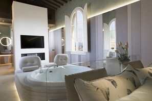Un baño moderno con bañera, un espejo grande y televisión.