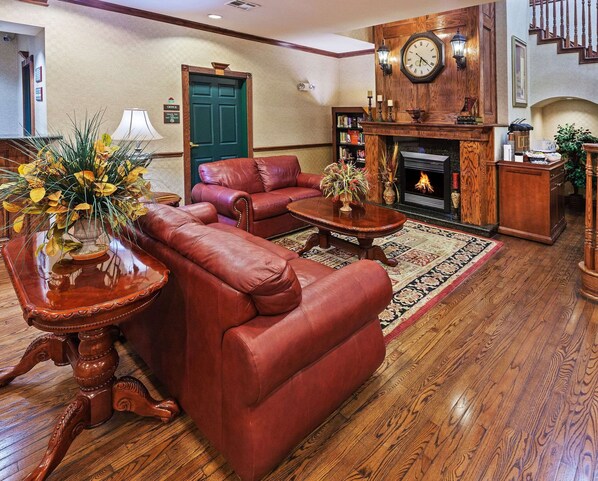 A traditional living room with leather sofas, a fireplace, and a clock on the wall.