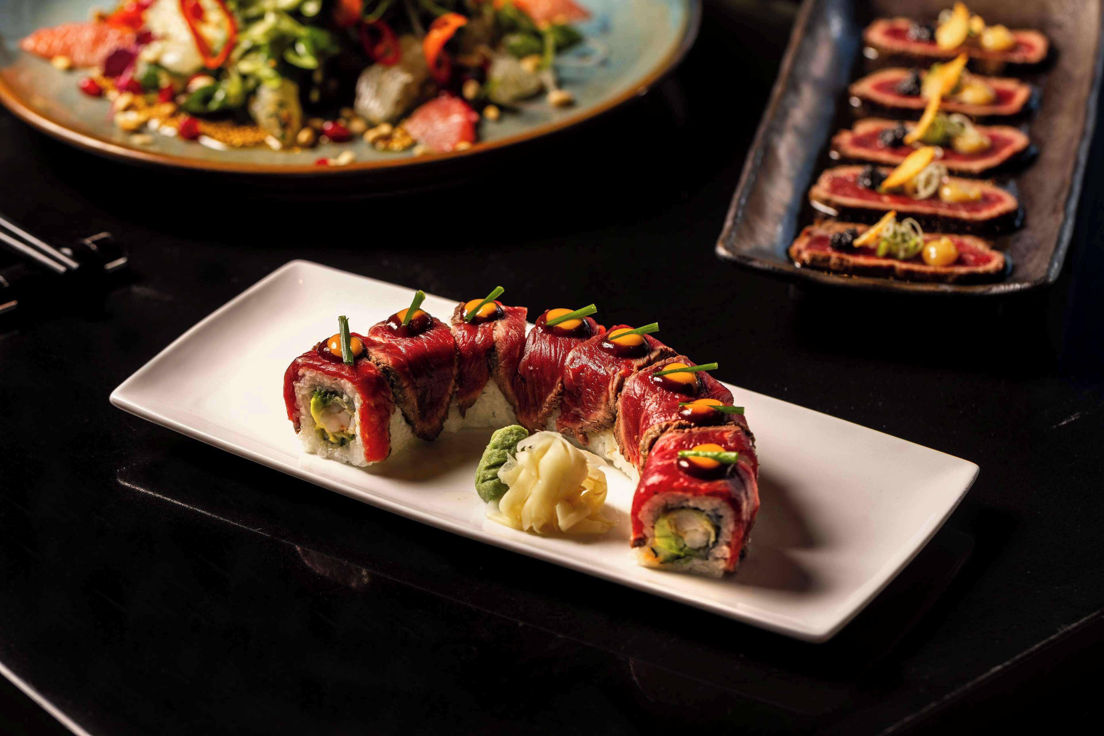 A plate of sushi with a variety of toppings and garnishes.