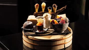A dessert tray with ice cream cones, a chocolate dessert, and a bowl of mixed berries.