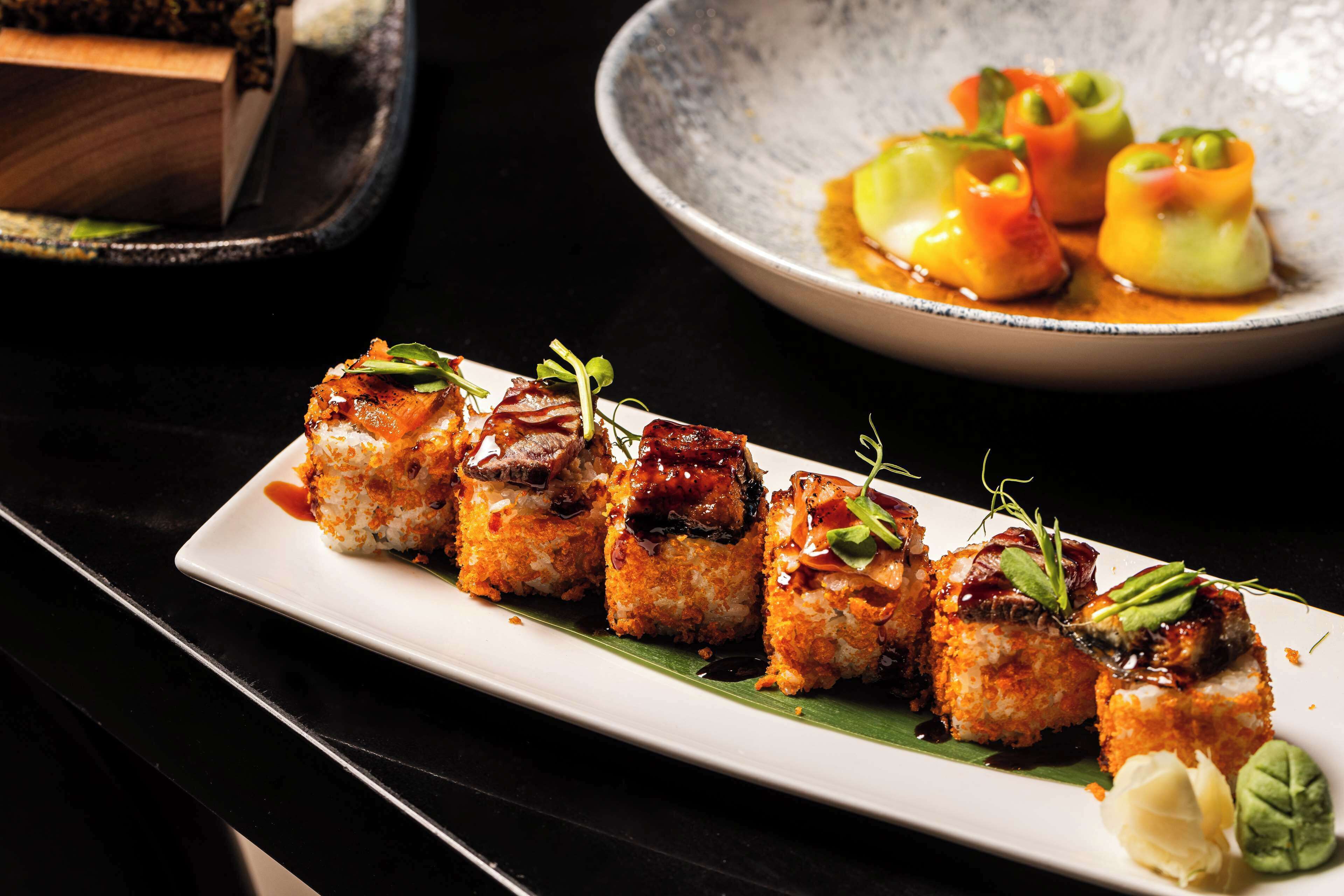 A plate of sushi with a variety of toppings and garnishes.