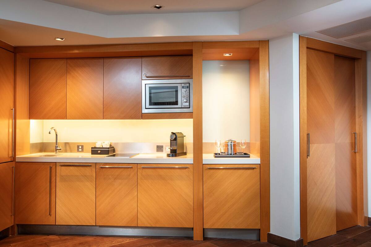Una cocina moderna con armarios de madera, un microondas y una cafetera.