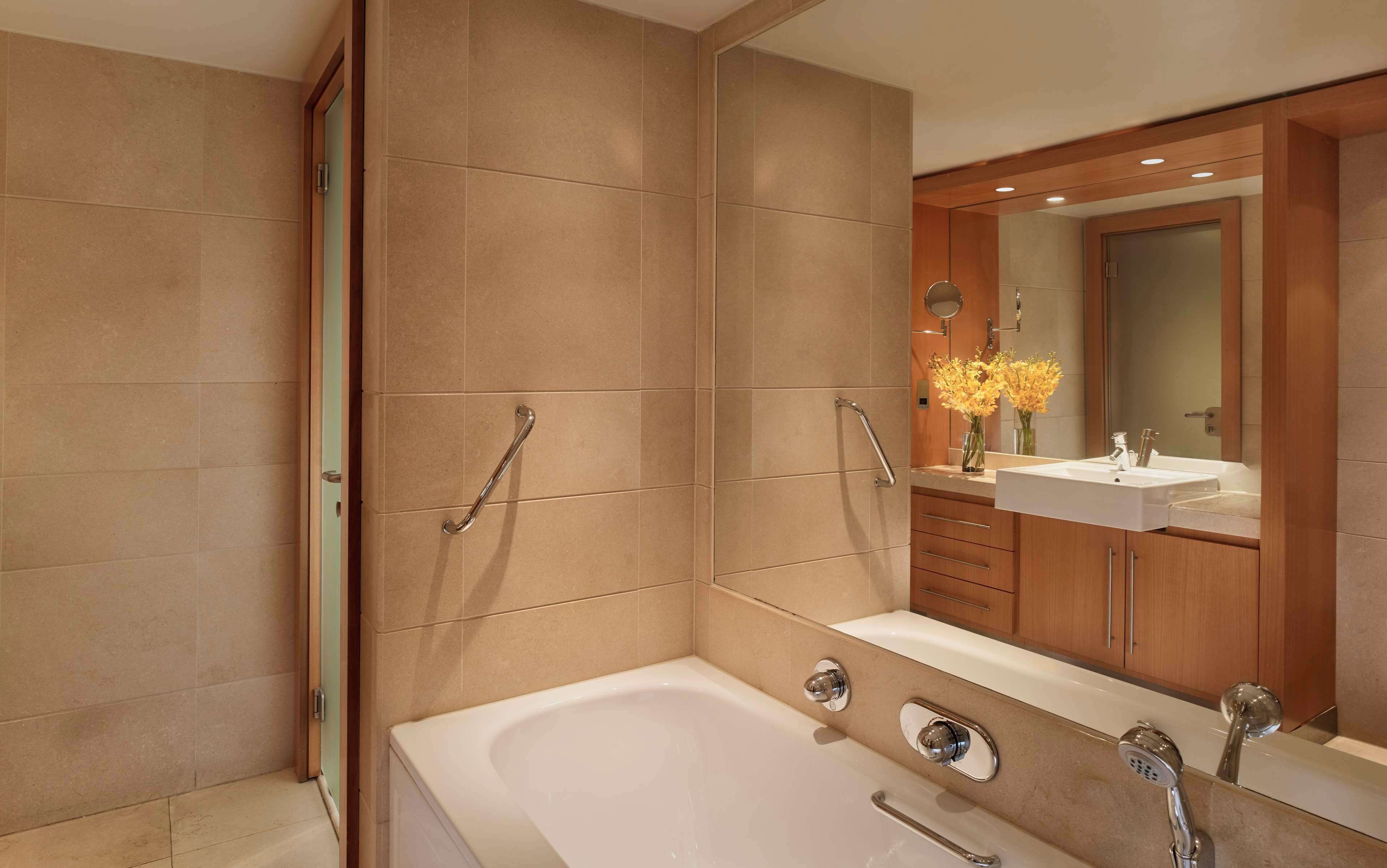 A modern bathroom with a bathtub, a sink, and a shower area.