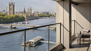 Un balcón con vista al río, un barco y la torre del reloj Big Ben.