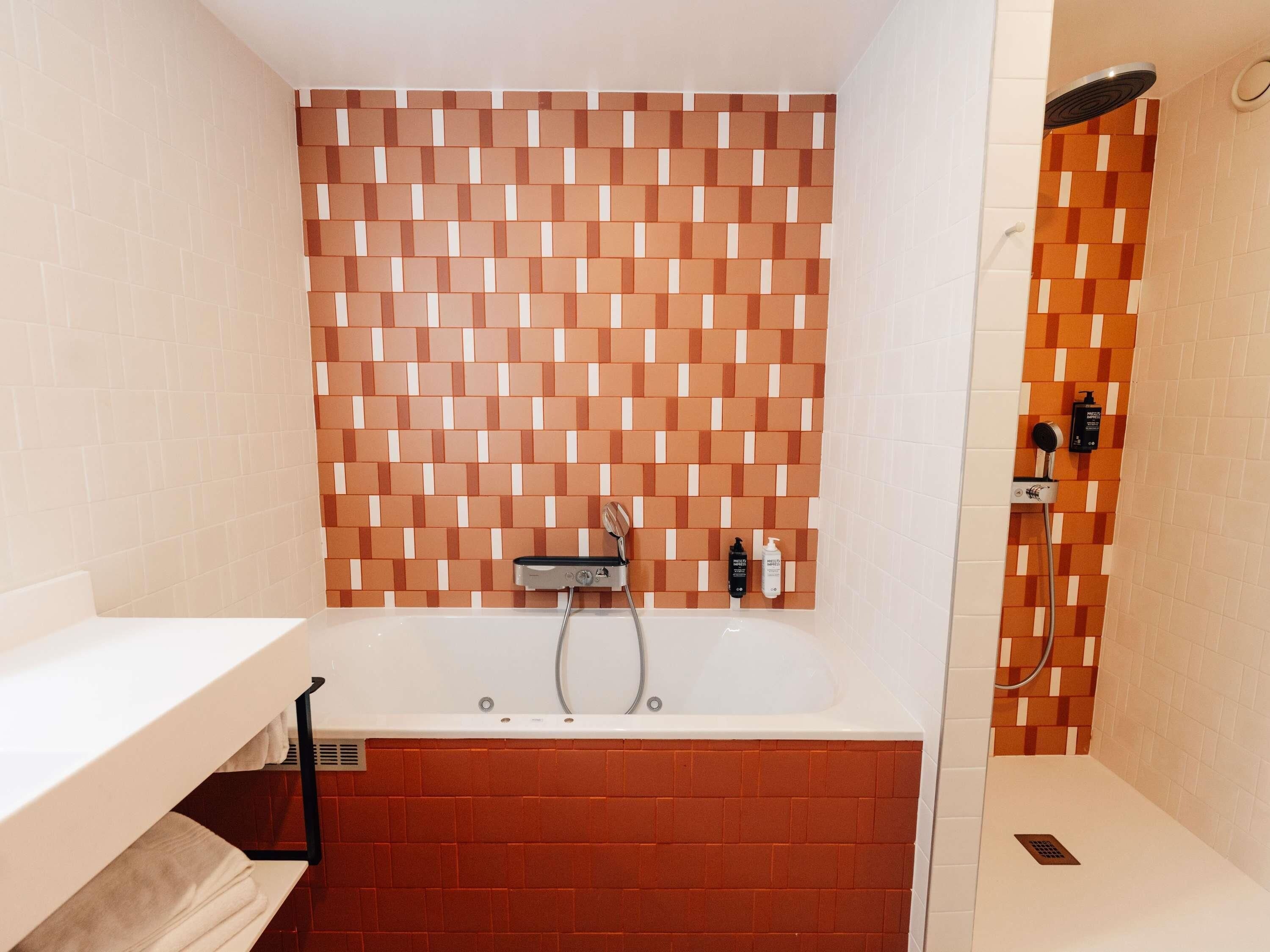 Ein Badezimmer mit einer Badewanne, einer Dusche und einem Handtuchhalter.