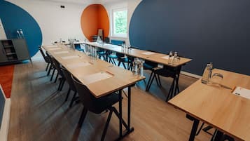 A conference room with long tables, chairs, and water bottles.