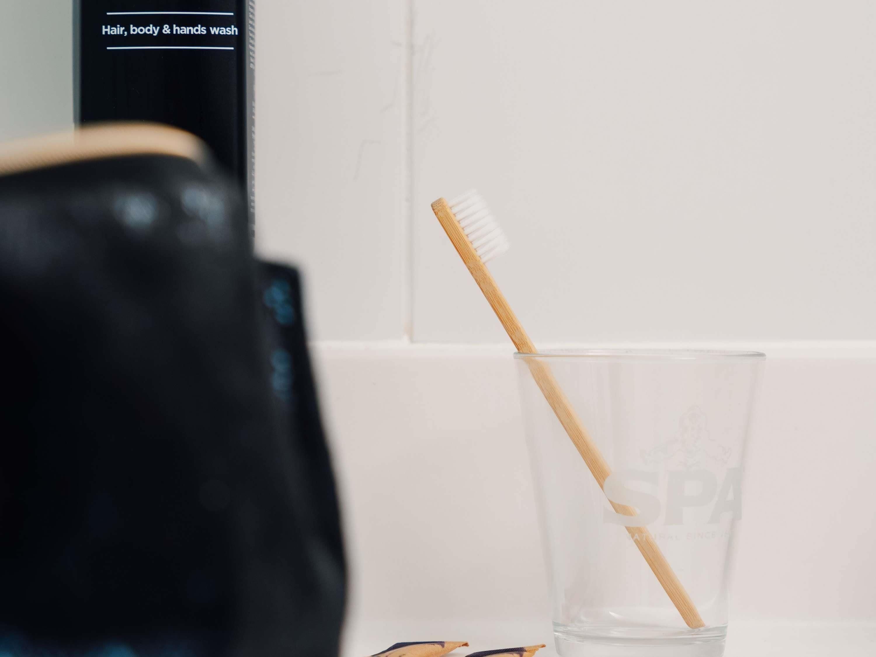 Une salle de bain avec un verre d’eau et une brosse à dents.