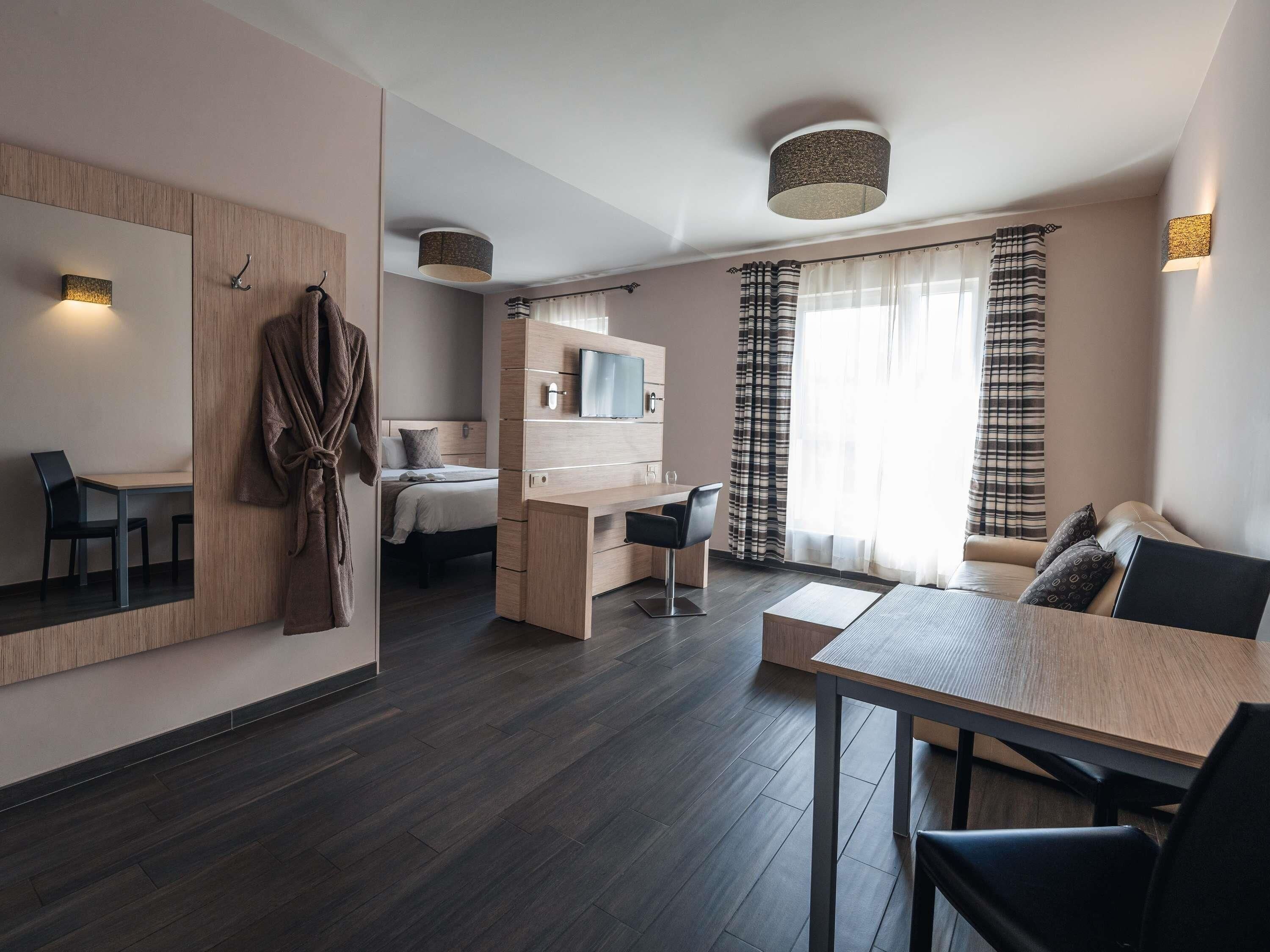 Une chambre d’hôtel moderne équipée d’un lit, d’un bureau, d’un canapé et d’une table à manger.