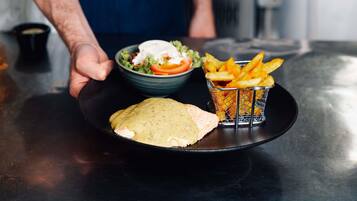 A plate with a sandwich, a bowl of salad, and a basket of fries.