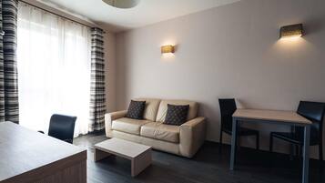 Una sala de estar moderna con sofá, mesa de centro y mesa de comedor.