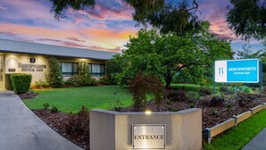 The entrance to the Beechworth Motor Inn with a well-maintained lawn and a clear sky. - Beechworth Motor Inn (Beechworth)