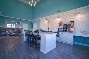A kitchen with a central island, bar stools, and a coffee machine. - Hotel Bliss Kemah (Kemah)