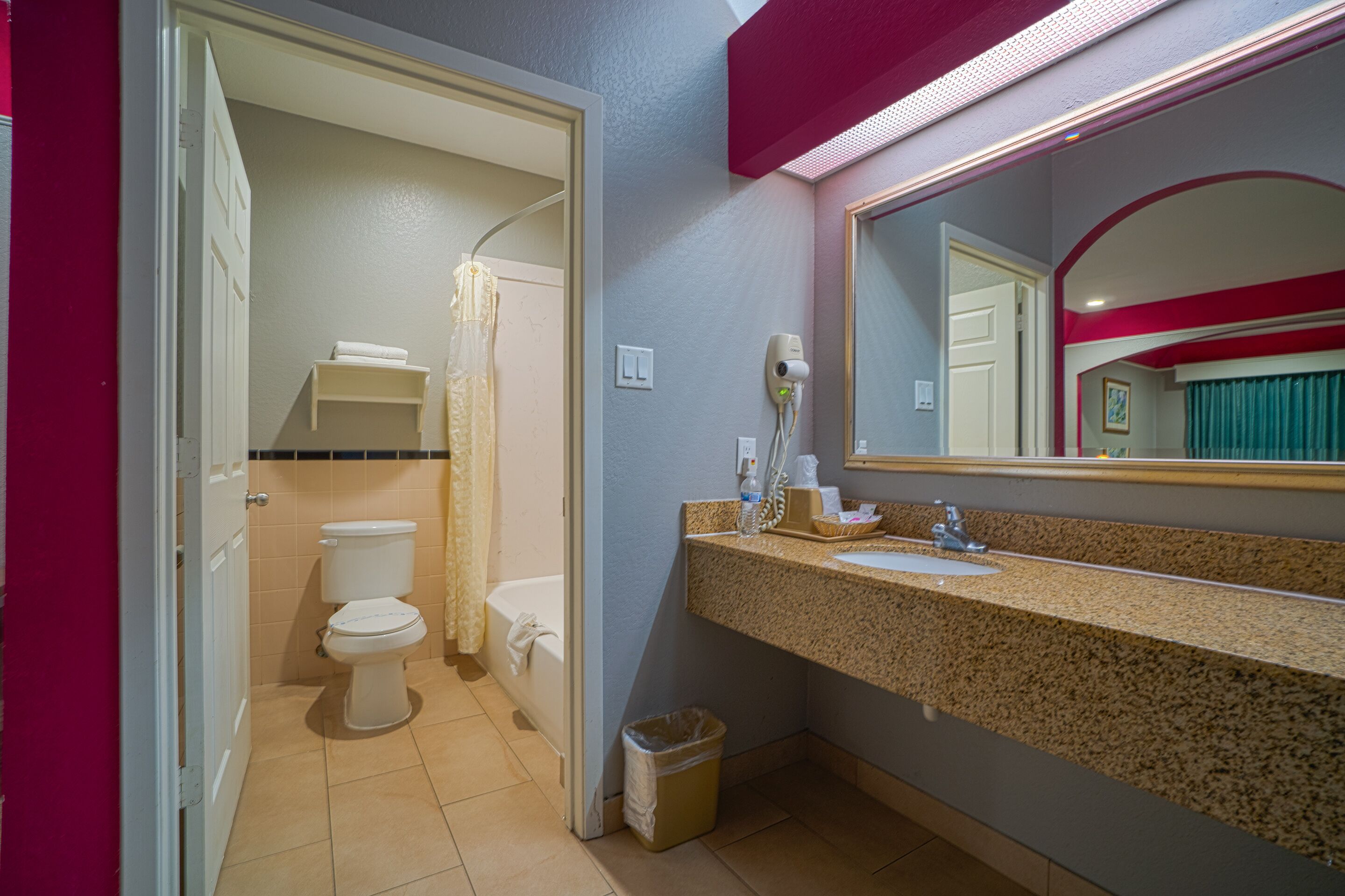 Un baño con inodoro, lavabo y espejo.