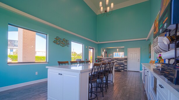 A spacious kitchen with a large island, bar stools, and a view of the outside. - Hotel Bliss Kemah (Kemah)