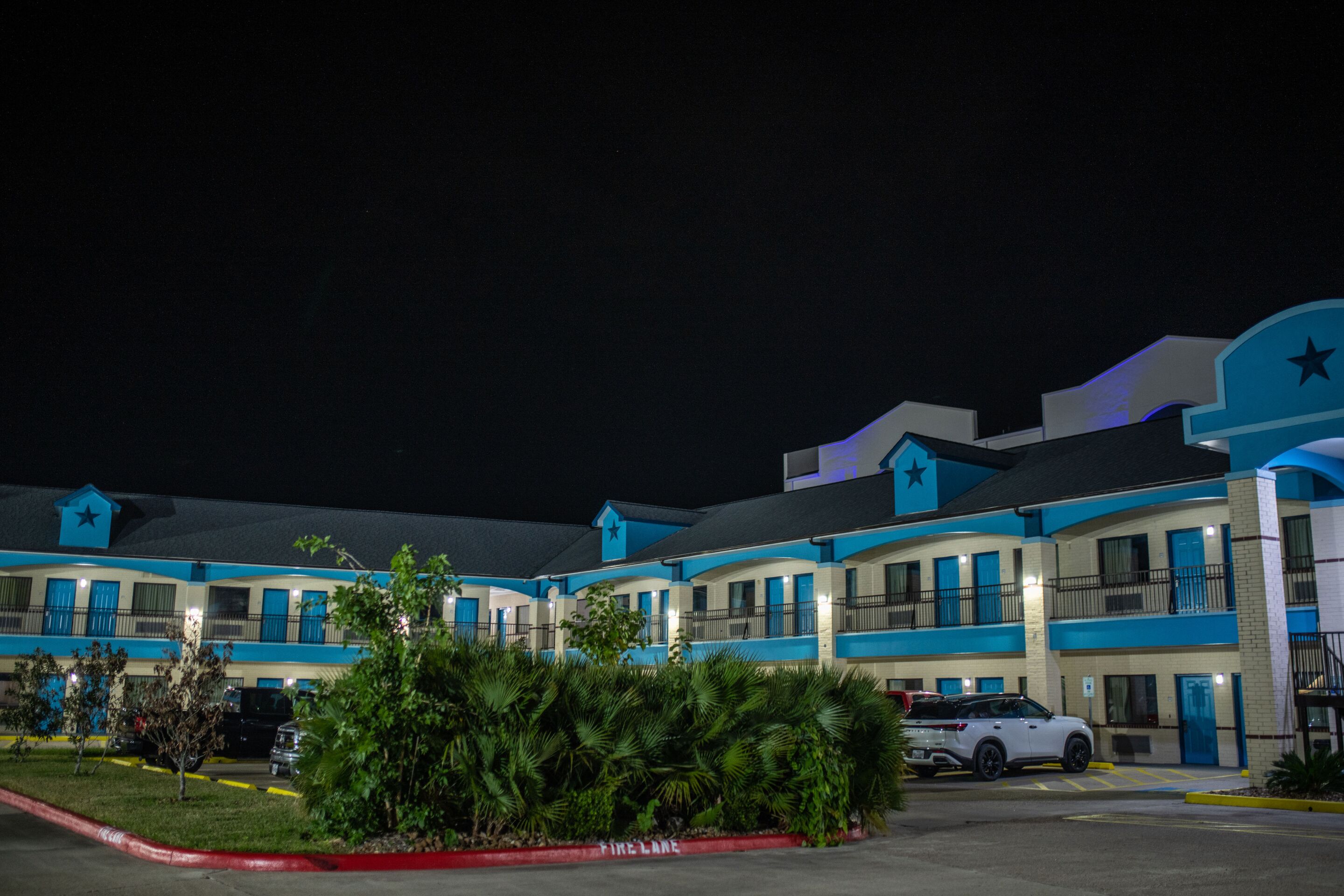 A motel with multiple units, each featuring balconies and a star logo on the facade.