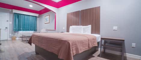 Un dormitorio con cama, mesita de noche, armario y ventana con cortinas.