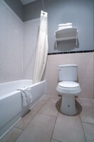 Un baño con bañera, inodoro y un perchero para toallas.
