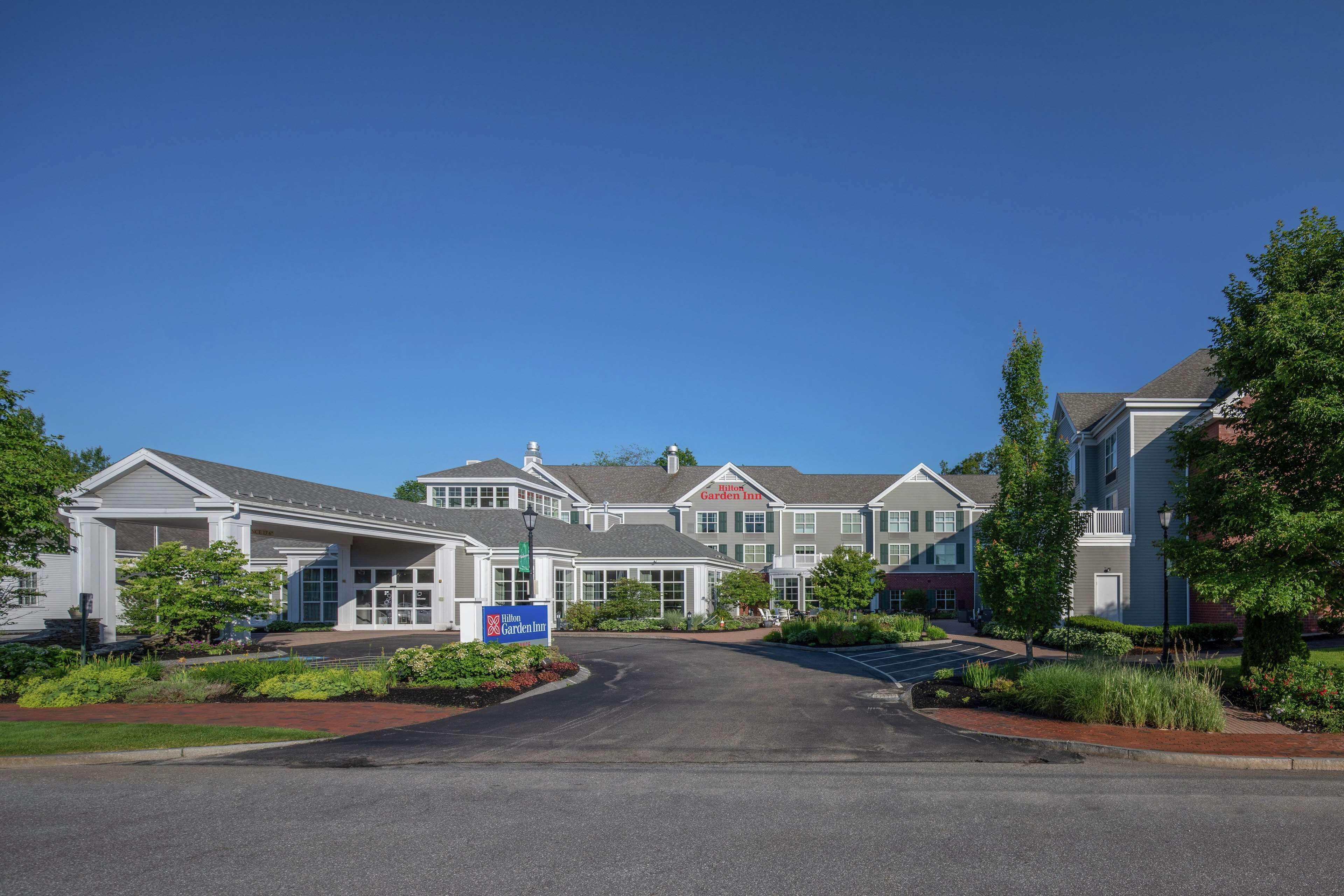 A hotel with a central entrance, multiple buildings, and a landscaped driveway.