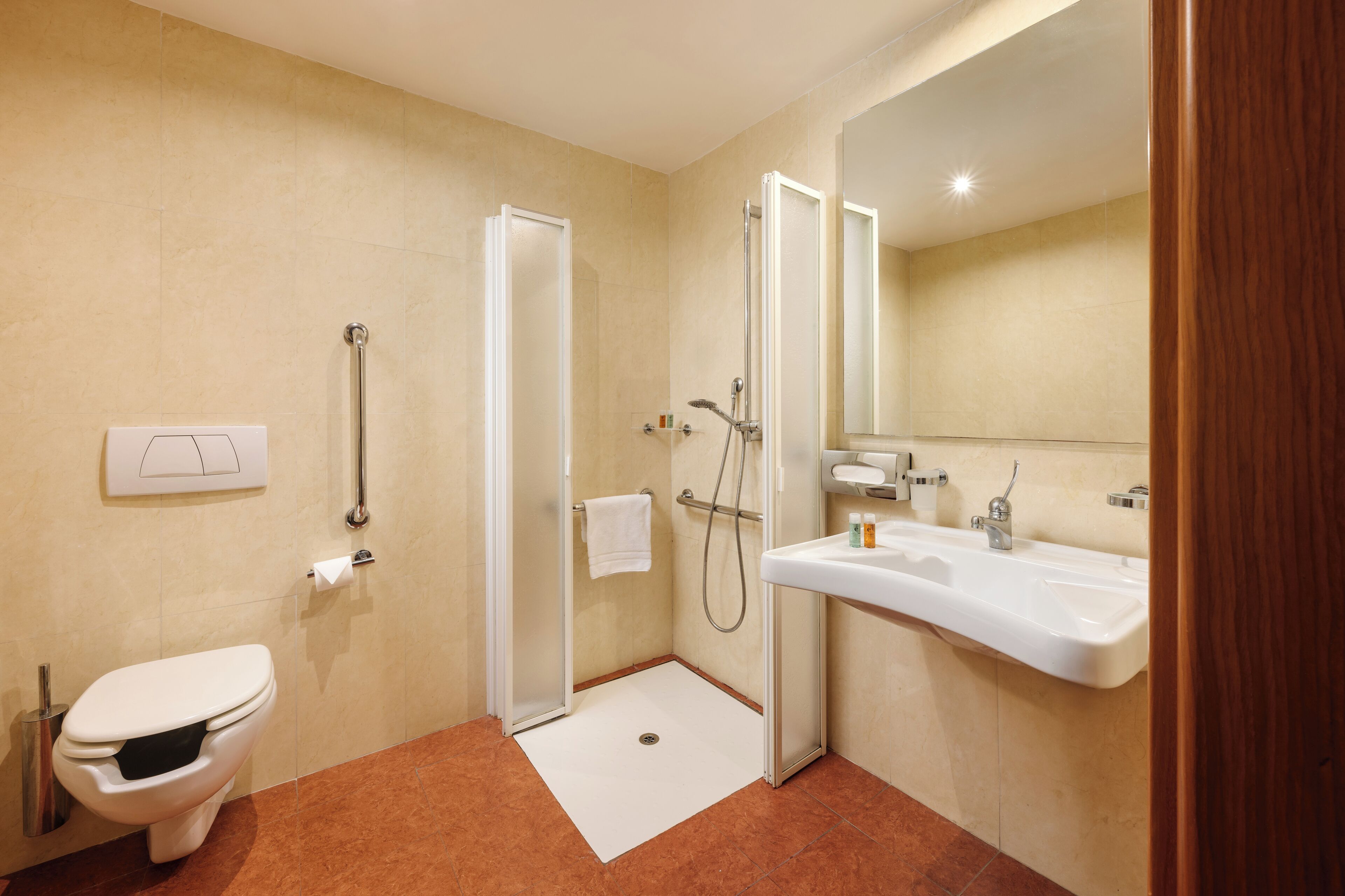 Une salle de bain moderne comprenant des toilettes, une douche avec une porte en verre et un lavabo avec un miroir.