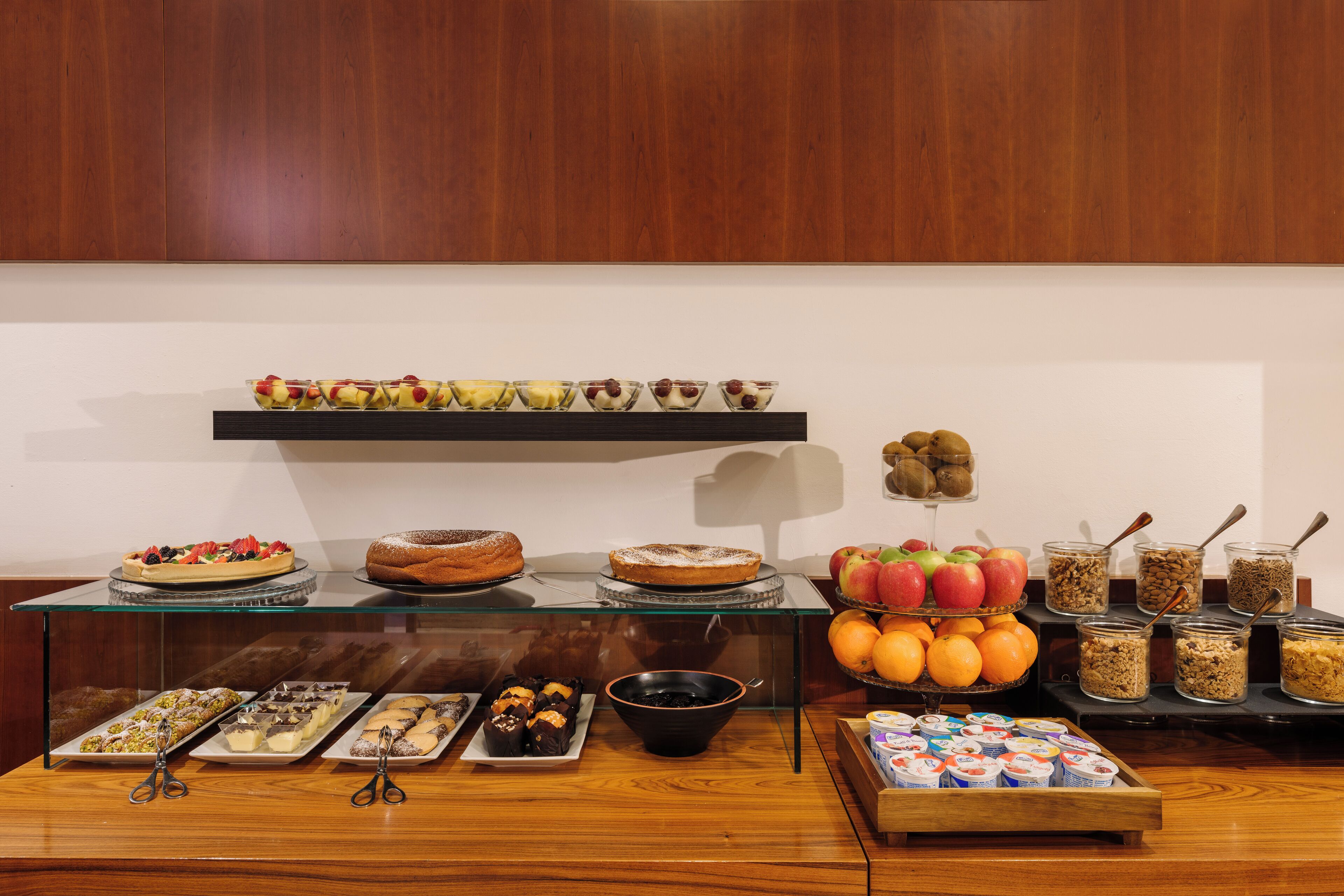A buffet table with various food items and a fruit display.